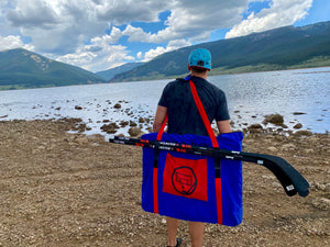 A man looking at the Rocky Mountains with a Sauce Toss Travel Bag on his back